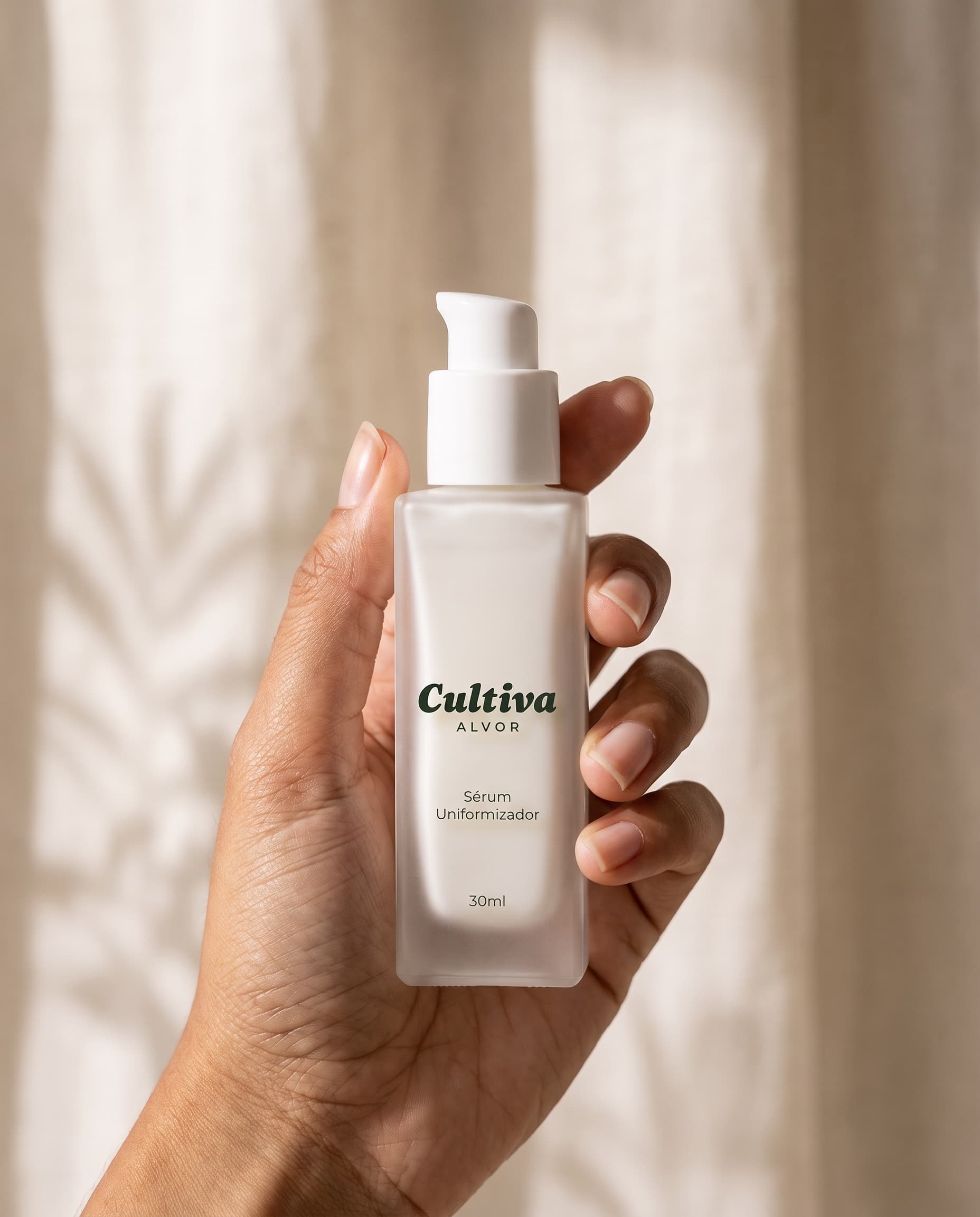 Mão segurando o frasco de 30ml do Sérum Uniformizador Cultiva em luz natural